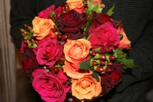 Hot pink, bright orange and deep red rose and Hypericum bouquet